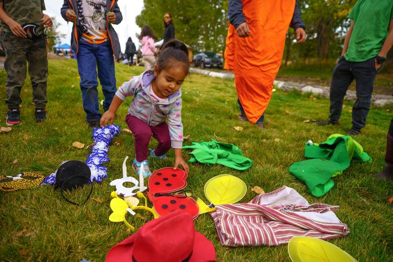A young girl choosing dress-up costumes at a Boys and Girls Club event